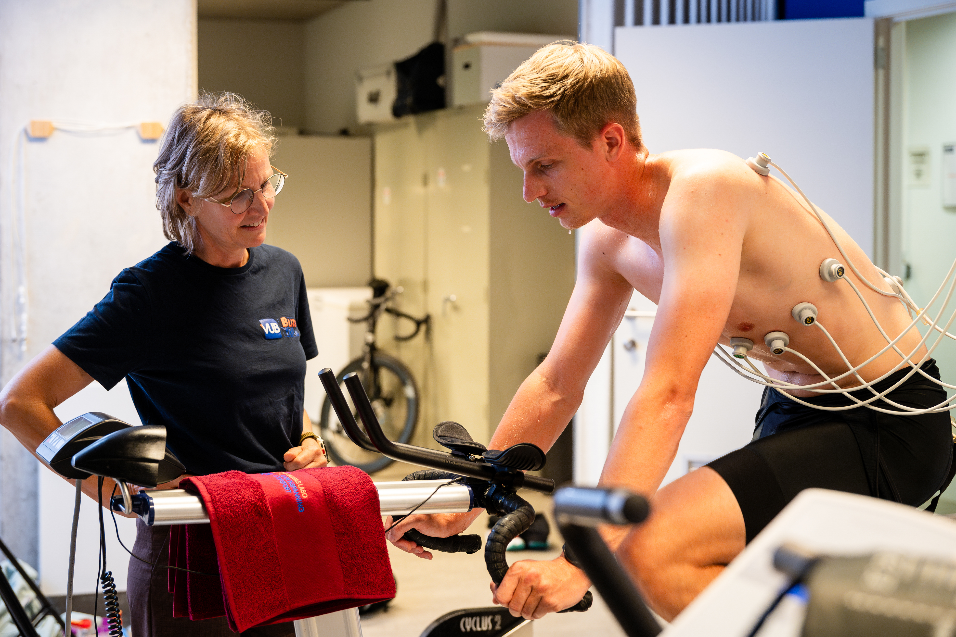 Researcher supervises athlete during excercise test on bicycle